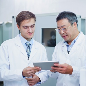 Two scientists looking at a tablet