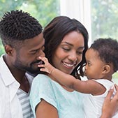 Happy African-American parents holding their inquisitive toddler