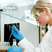 Female scientist in safety goggles and gloves working with chemicals