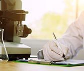 Chemist writing on clipboard while working in a laboratory